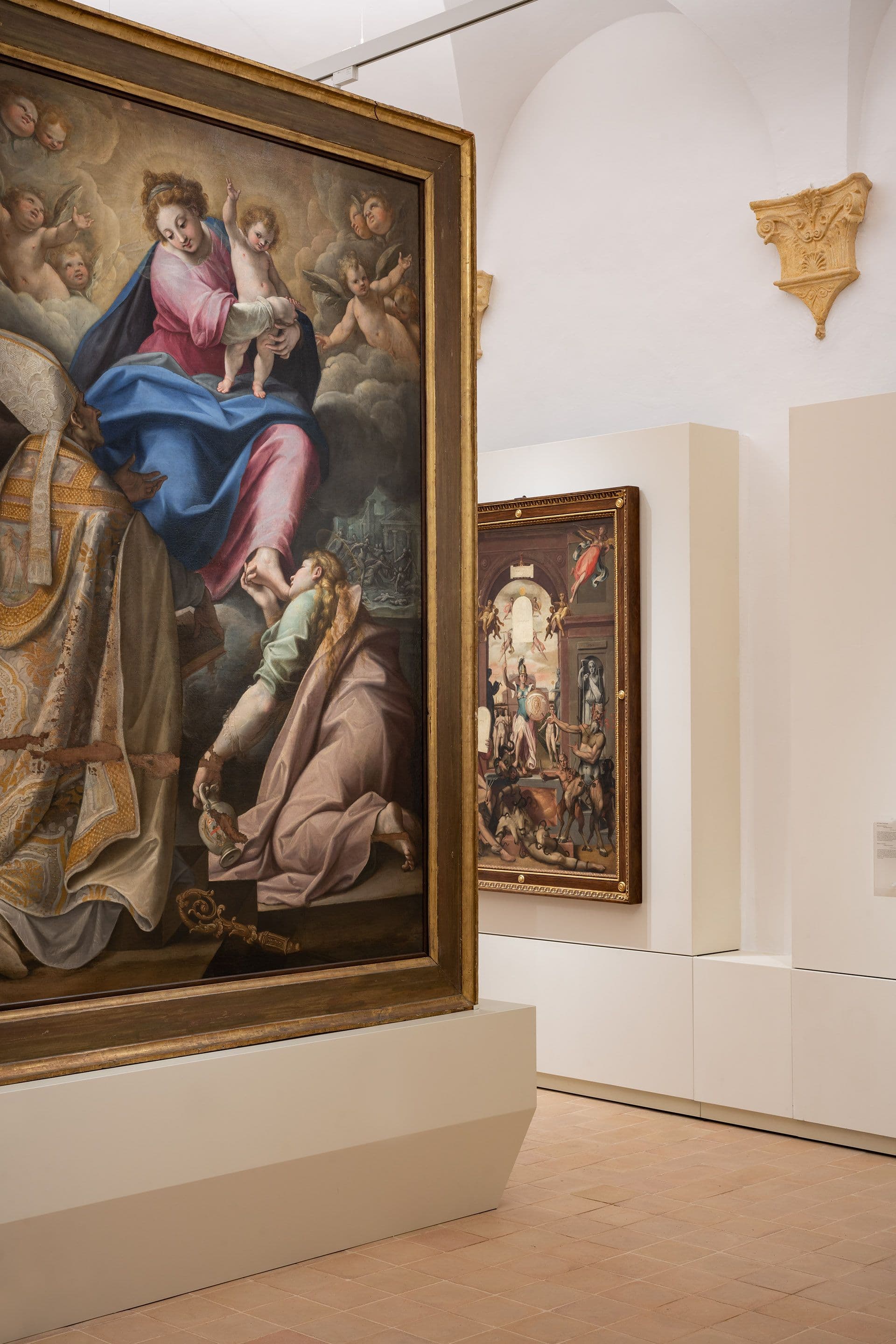 Dettaglio di una sala museale con una grande pala d’altare raffigurante la Madonna col Bambino e figure sacre, esposta accanto ad altri dipinti rinascimentali.